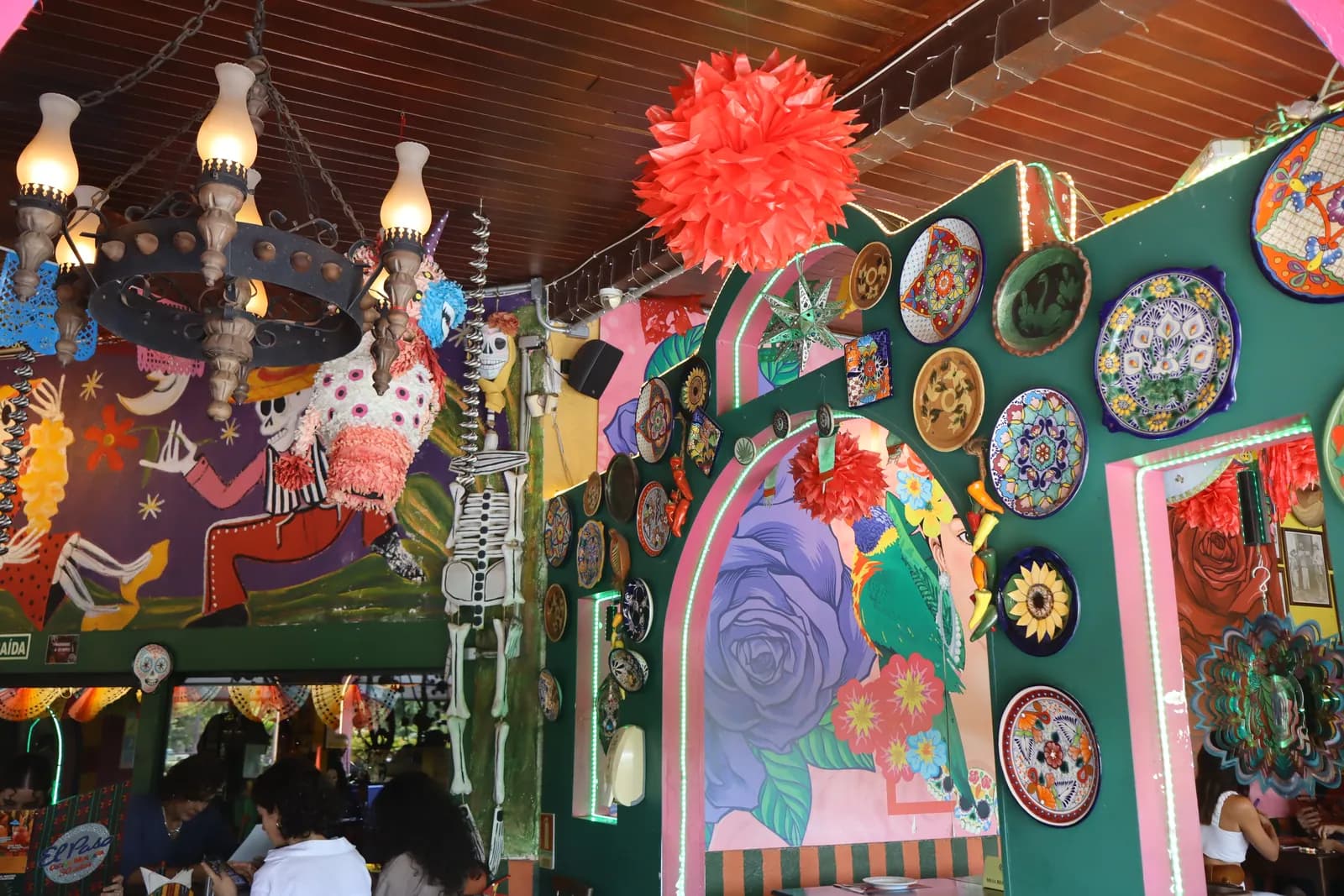Lustre, piñata e parede de pratos vistos do corredor central