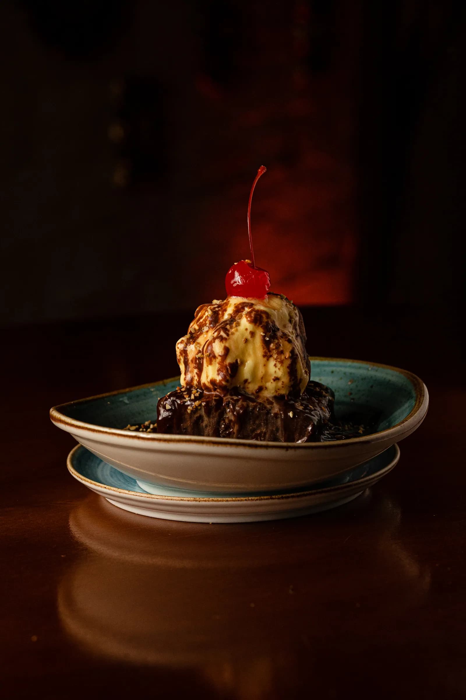 Chocolate brownie sundae com sorvete, calda de chocolate e cereja