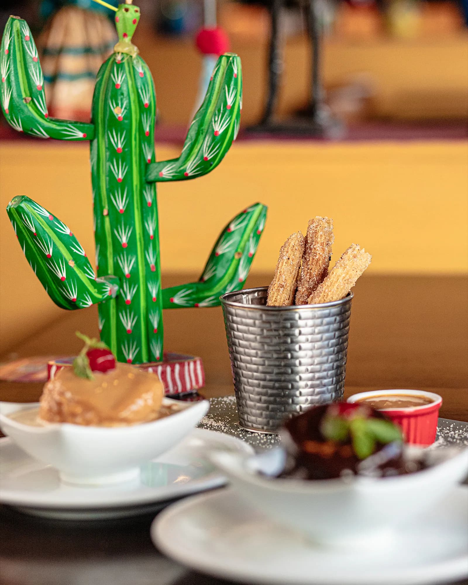 Churros polvilhados de açúcar e canela com doce de leite e calda de chocolate