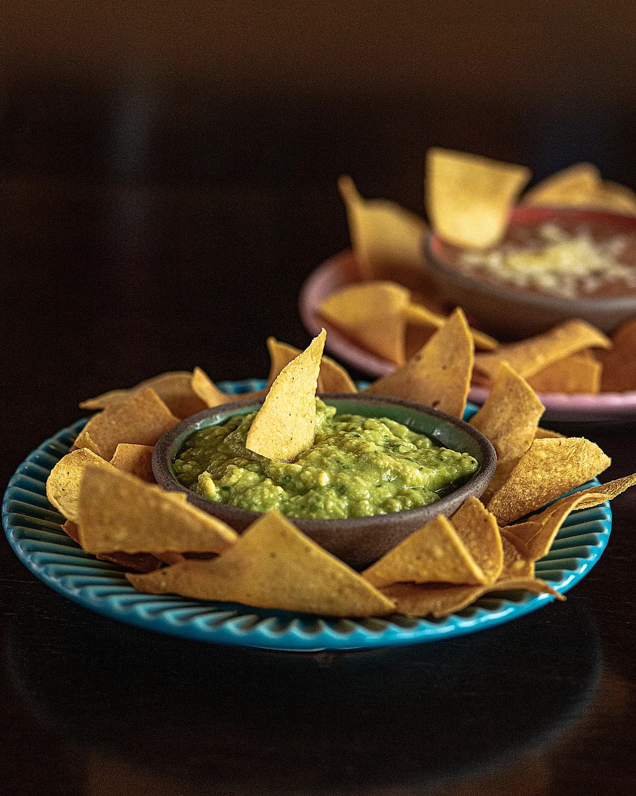 Guacamole fresco na tigela de pedra cercado de totopos crocantes