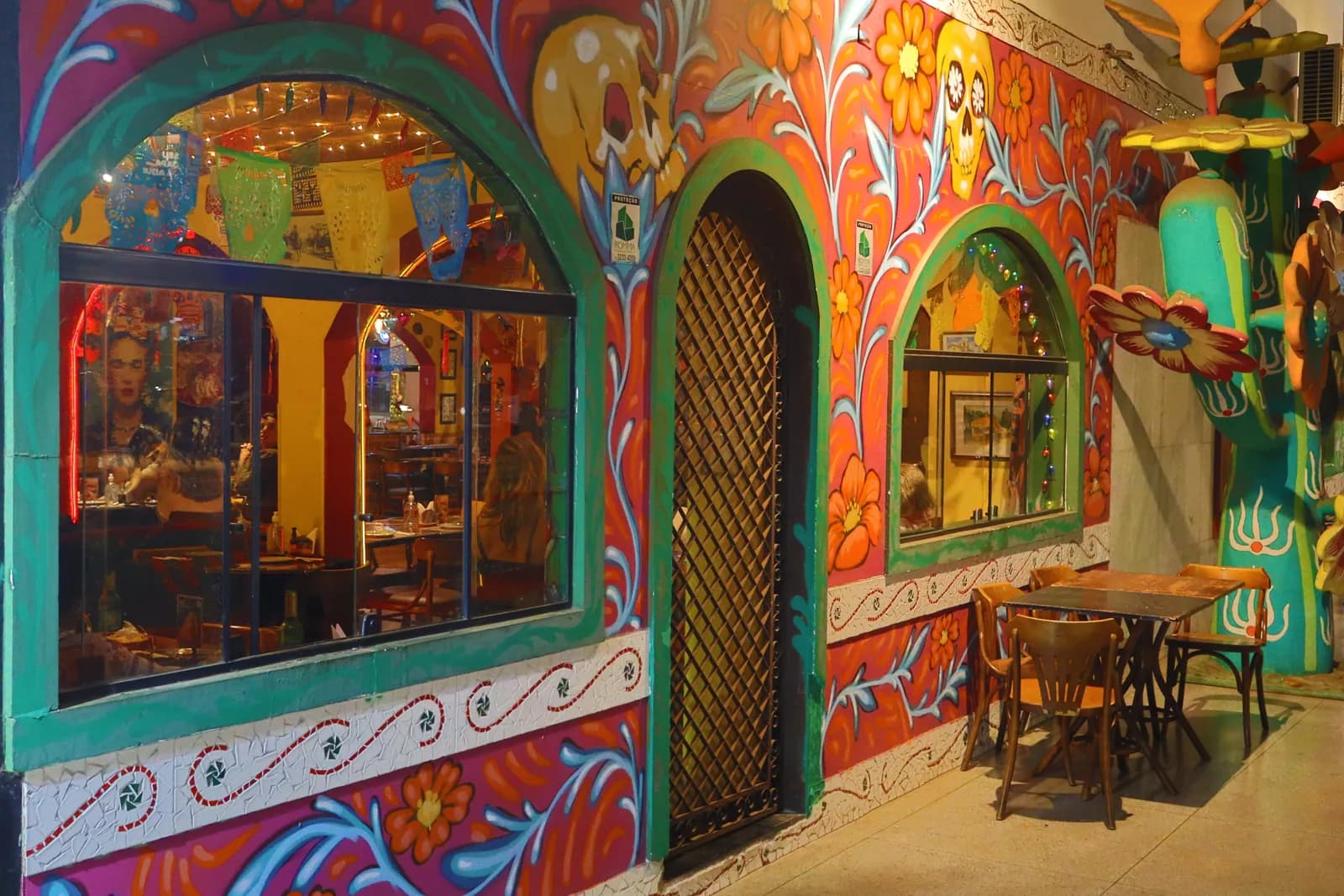 Fachada ampla com dois arcos revelando o corredor de entrada e mural lateral