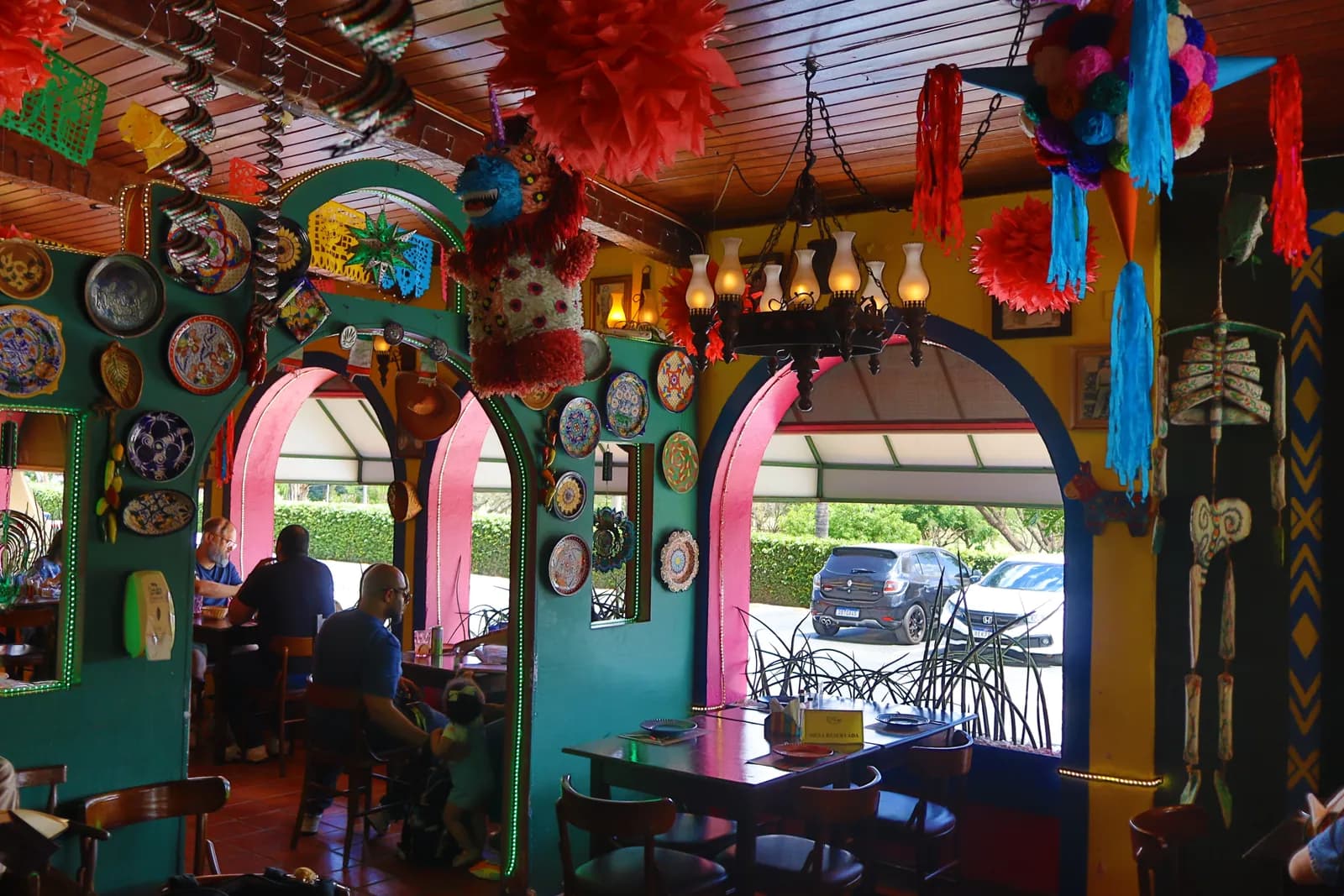 Área coberta do Terraço com lustre, parede de pratos decorativos e piñata